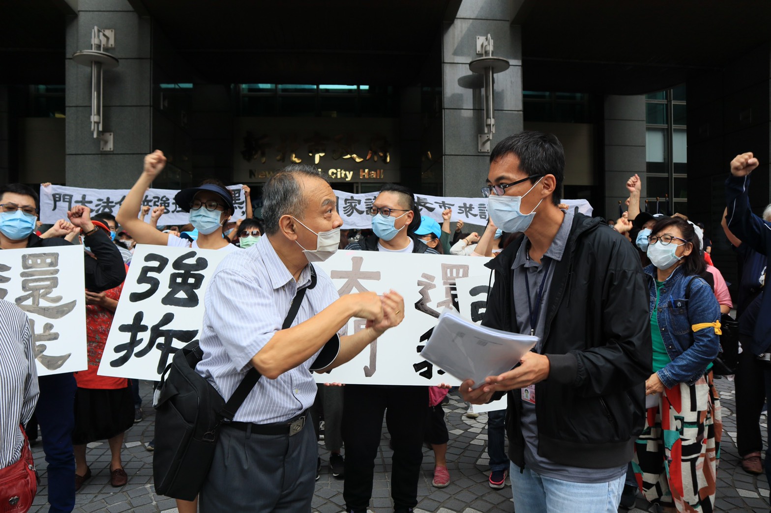 黎明清境社區住戶於14日上午來市府陳情，由住戶代表葉承(左)遞交陳情書，市府方面由工務局總工程司蘇志民(右)代表接受陳情。