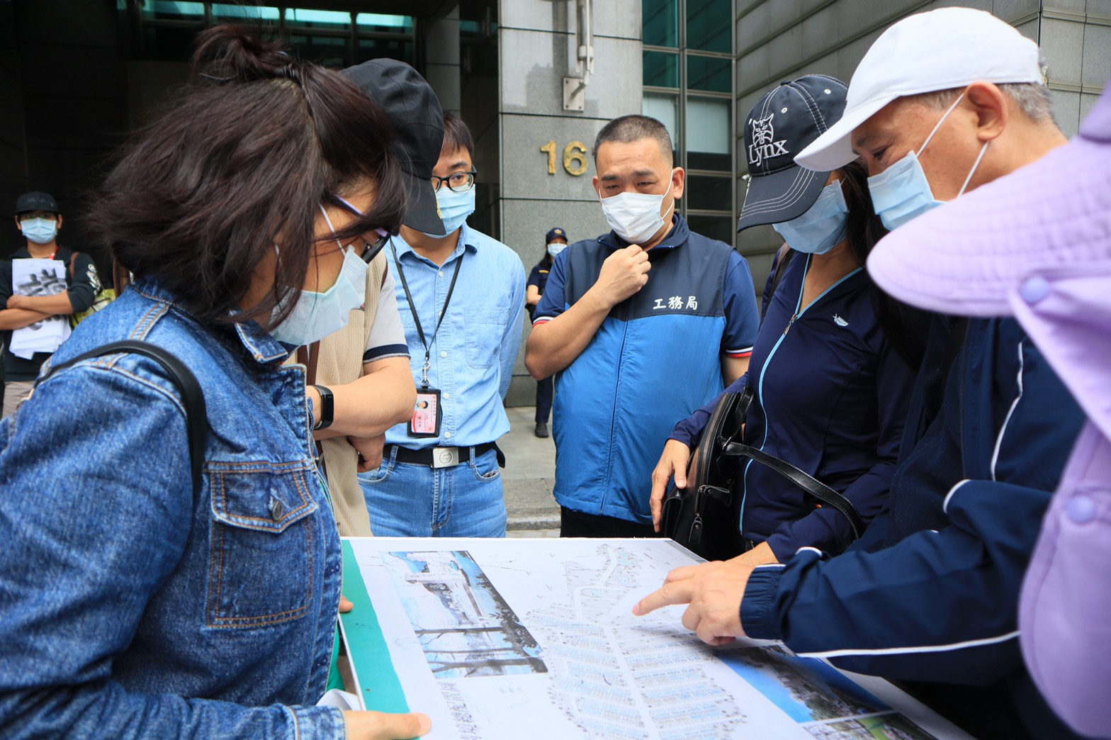 工務局公寓大廈管理科在陳情現場向黎明清境社區住戶說明社區目前狀況。