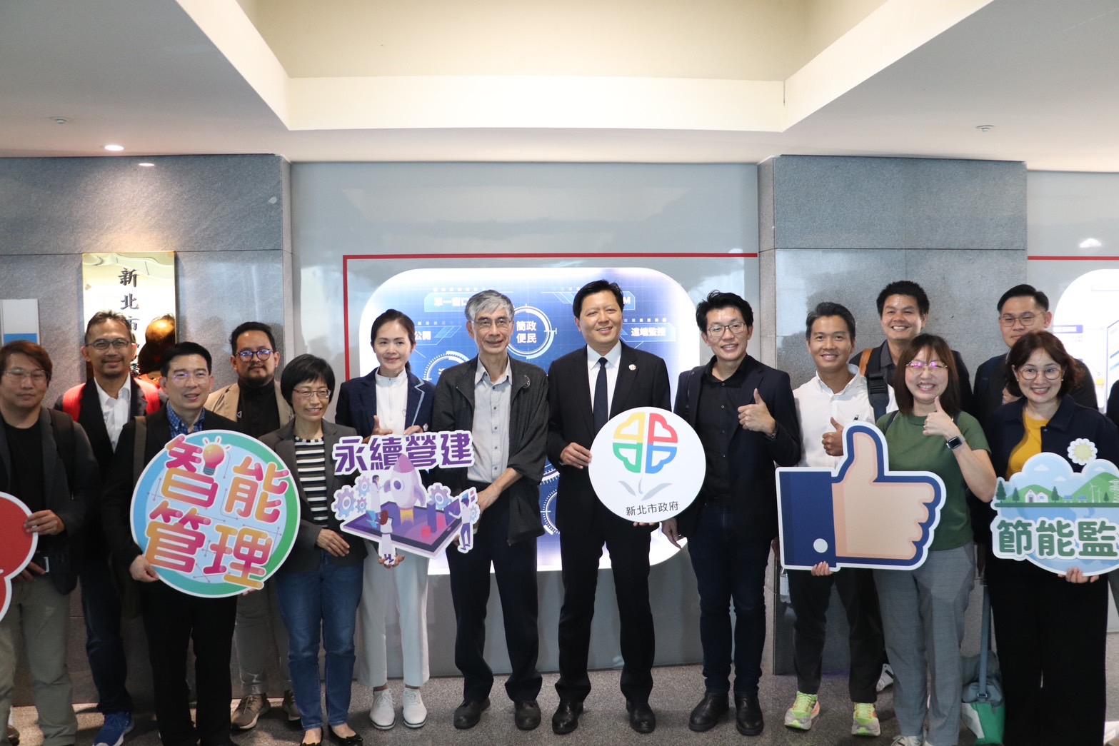 朱惕之副市長(第一排右5)、工務局長祝惠美(第一排左4)、台大BIM中心主任謝尚賢(第一排左5)及泰國BIM協會一同在道管中心門口合影留念，藉由本次城市交流，了解市府如何應用BIM技術，協助提升城市與能源管理之效率。