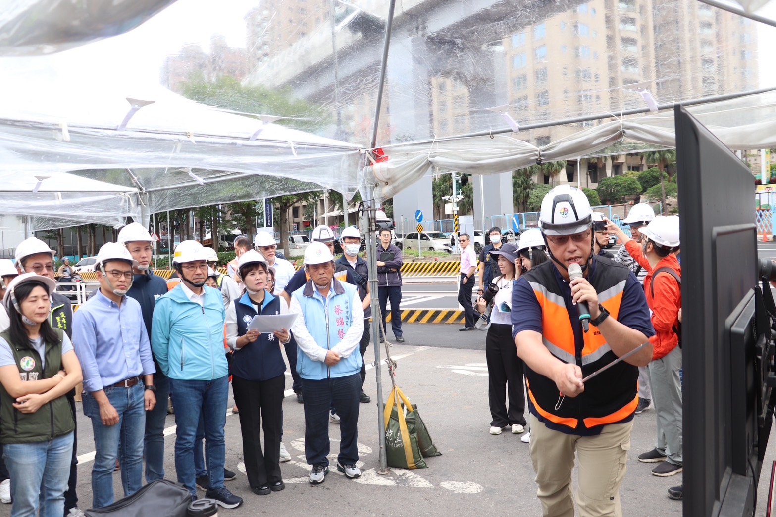 新工處長王益翔(前)向各位簡報淡北道路工程進度及交維計畫，並說明施工交維優先考量維持既有車道數，經過工序檢討及優化，採取縮減施工區域，以降低施工對交通造成的影響。