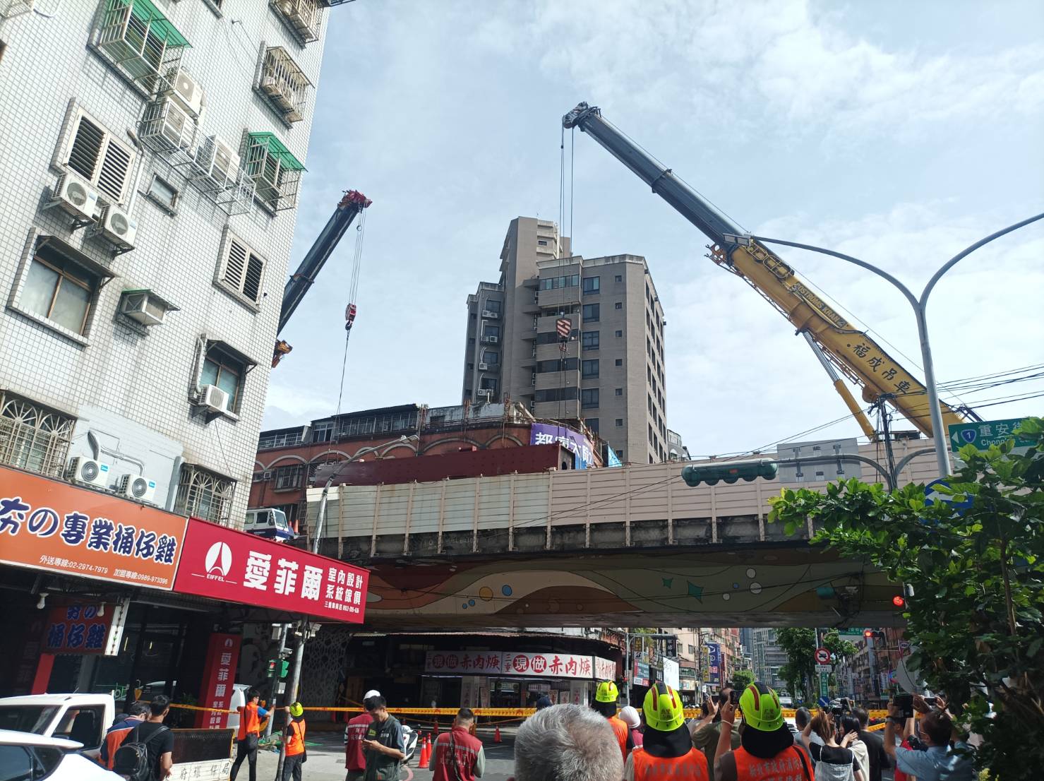 養工處施工廠商正在以大型吊車吊離在台一高架橋上翻覆的拖板車和鋼柱