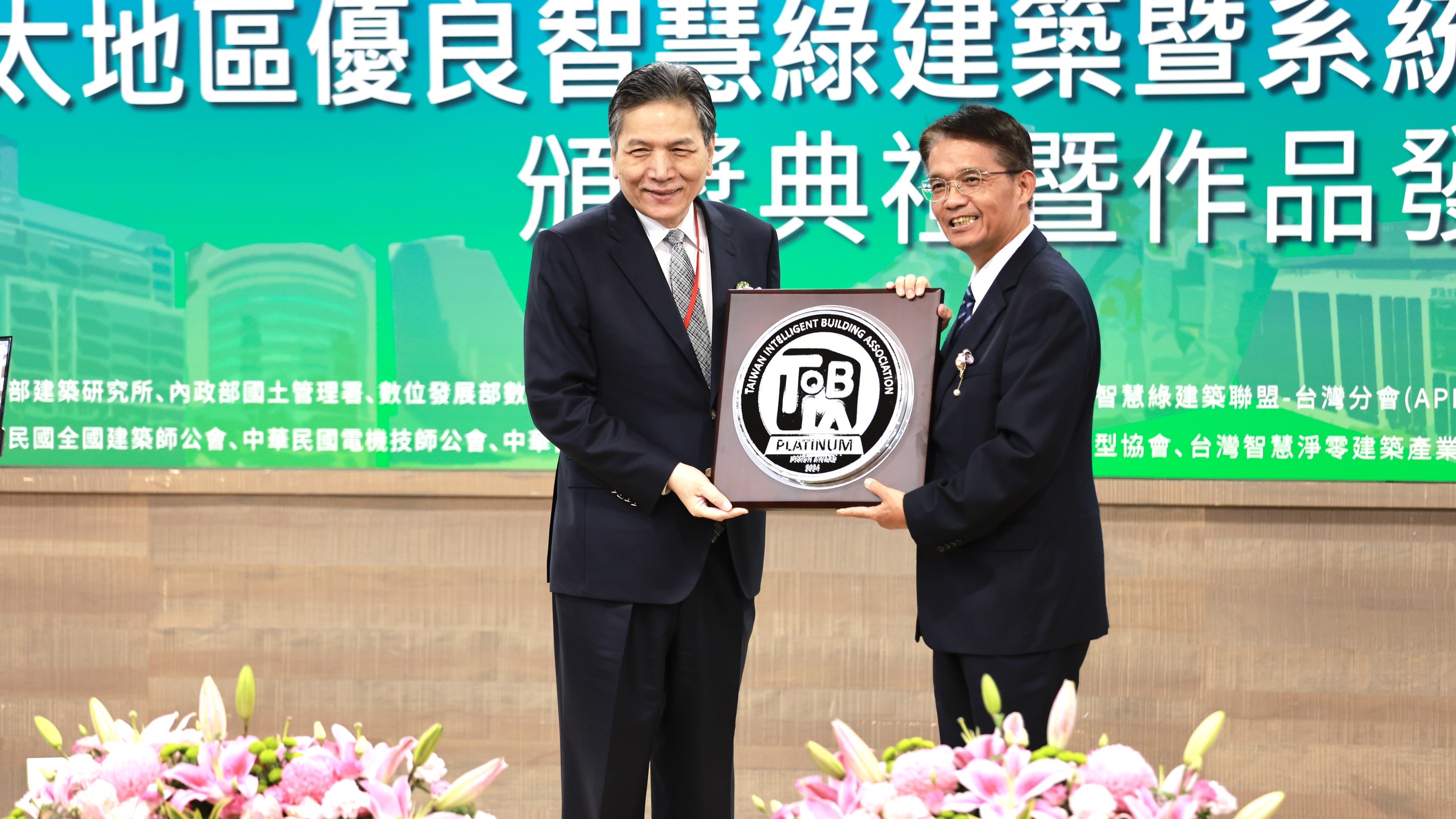 新北市政府參加「第四屆台灣優良智慧綠建築暨系統產品獎」競賽成果亮眼，一舉奪得設計類首獎-鉑金獎，今日由新北市政府秘書長邱敬斌（右），代表市府接受監察院副院長李鴻鈞（左）頒獎。