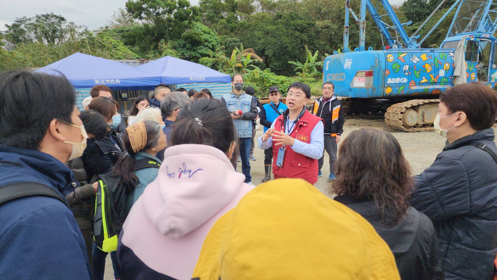 工務局今天上午安排三重六張街184號及190號兩棟建築物住戶前往八里暫置場認領物品，現場指揮官專門委員黃子毓（紅色背心）向住戶說明認領流程，並核對身份證明文件後開放民眾尋物。