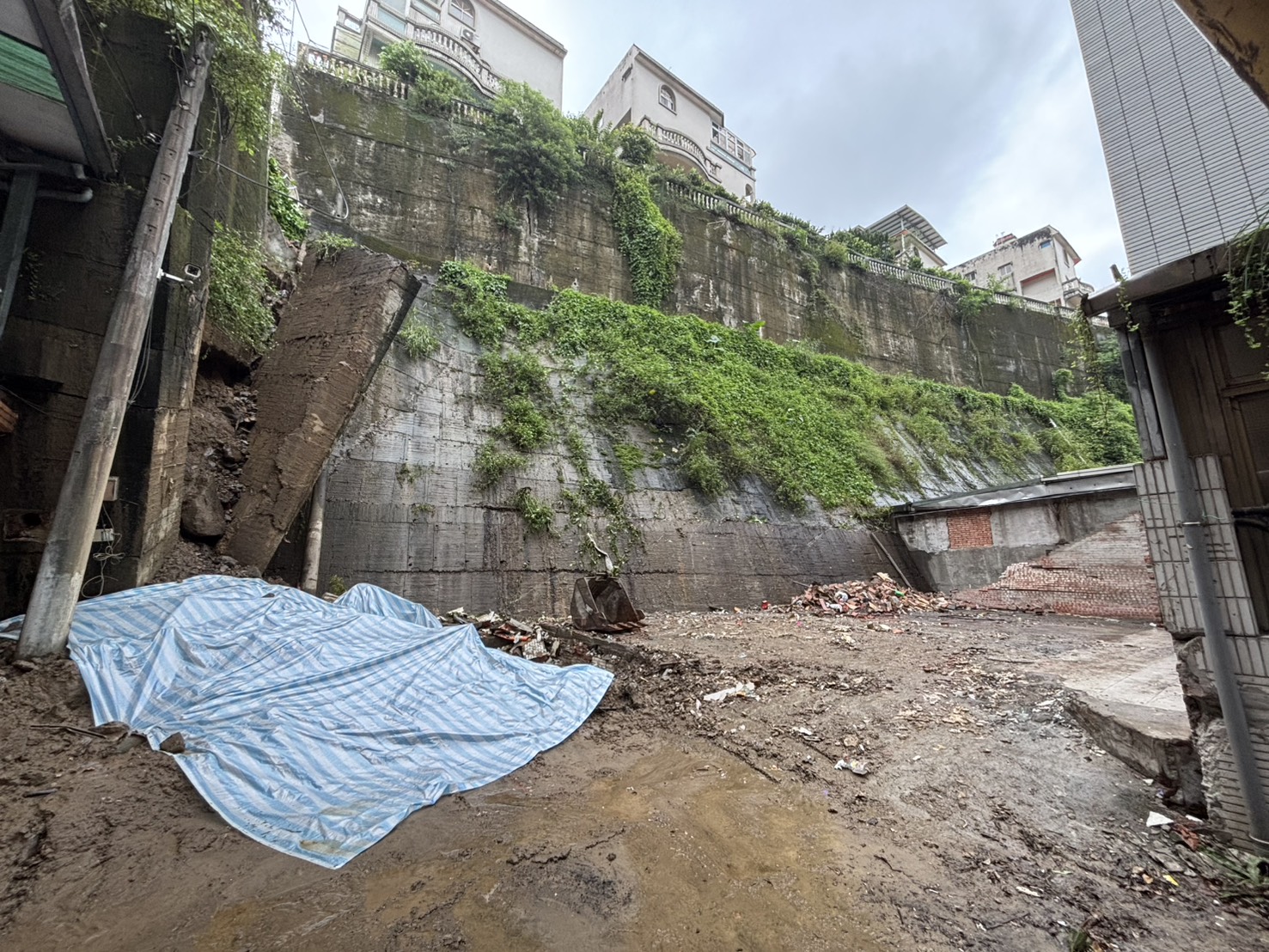 圖說 連日大雨造成新店區錦繡、碧瑤社區間擋土牆坍塌，工務局調派機具清除掉落土石並加蓋帆布，在安全無虞之下盡速復建。