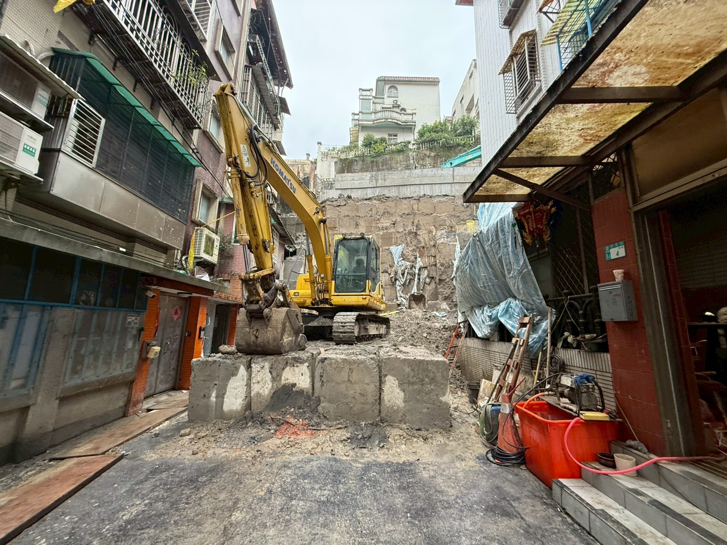 新店區錦秀、碧瑤社區間擋土牆遭逢大雨侵襲而坍塌，影響鄰近民宅，市府團隊全力搶修，逐漸發揮穩定邊坡功能。