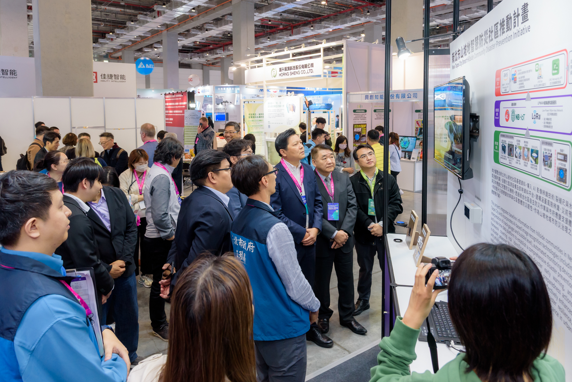 「新北市山坡地智慧防災社區計畫」運用AI技術結合裂縫尺與水平氣泡儀，即時掌握異常徵兆，政府能及早防範降低災害風險，新北市副市長朱惕之(右三)與工務局長馮兆麟(右二)也特地到訪了解推動成果。