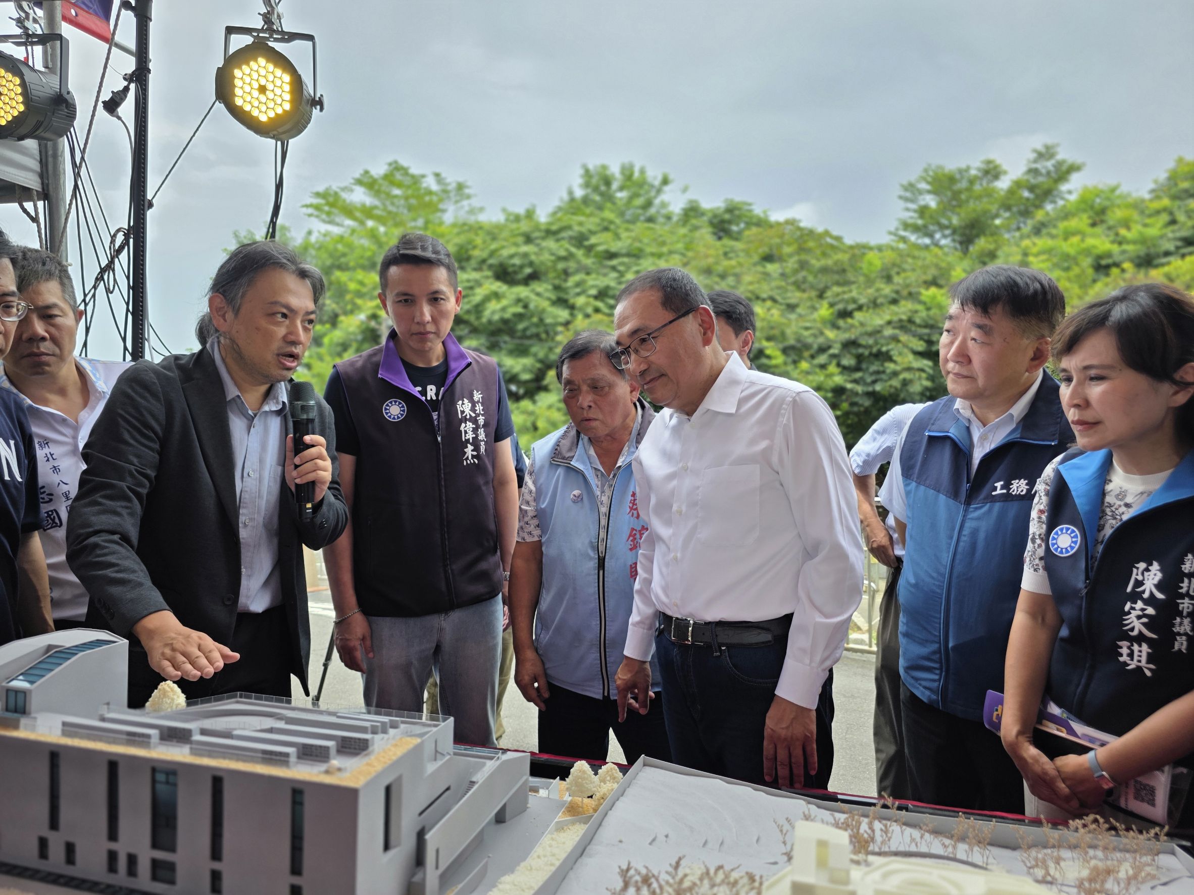 侯友宜市長(穿白襯衫者)觀看八里第二納骨塔的建物模型,建築師從旁解說。