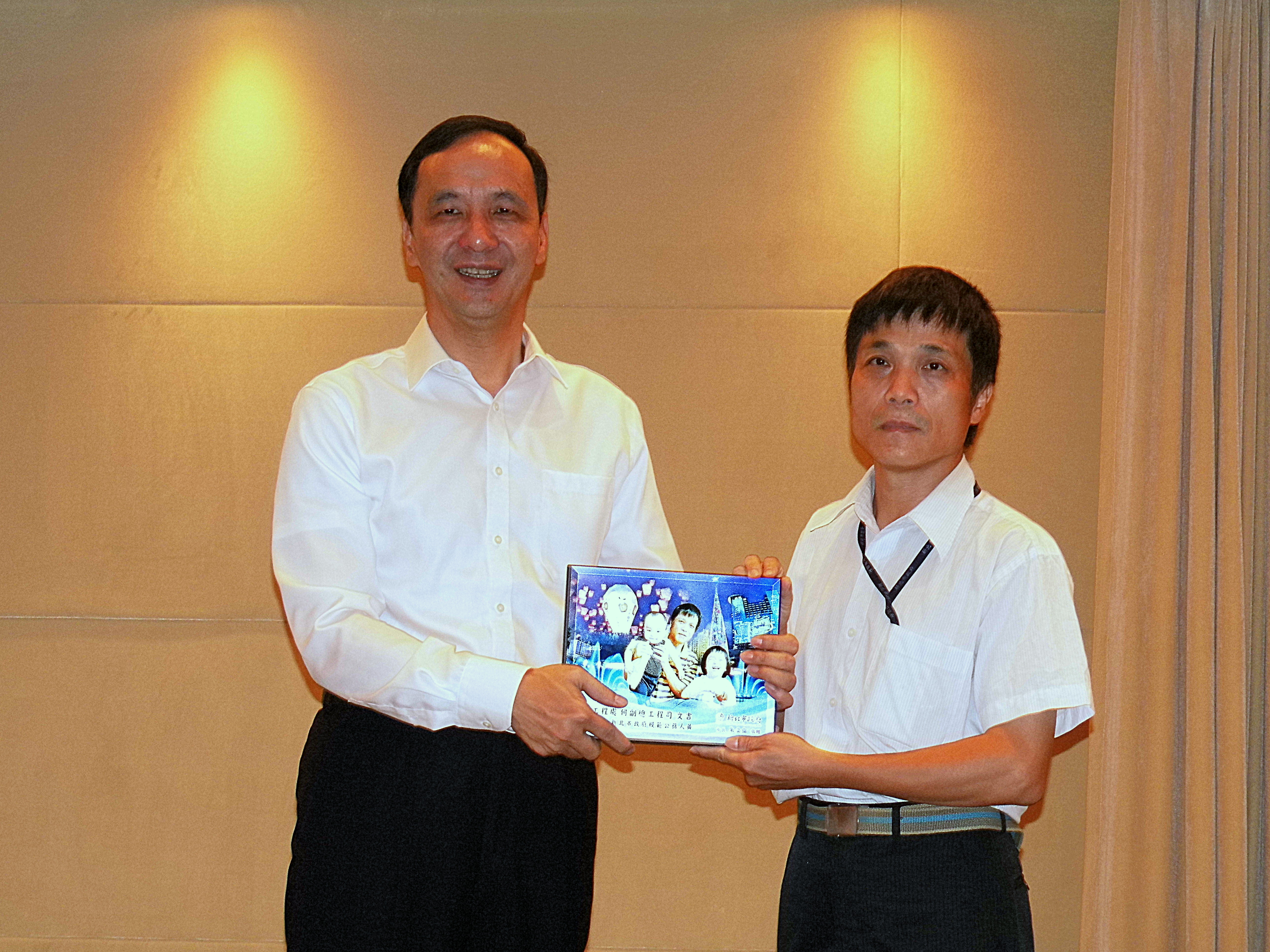 養工處副總工程司何文吉(右)榮獲新北市模範公務員獎，朱立倫市長頒發此榮譽